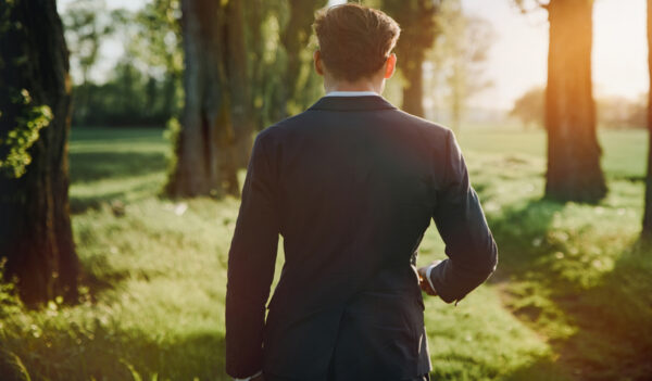 Man in suit walking through field